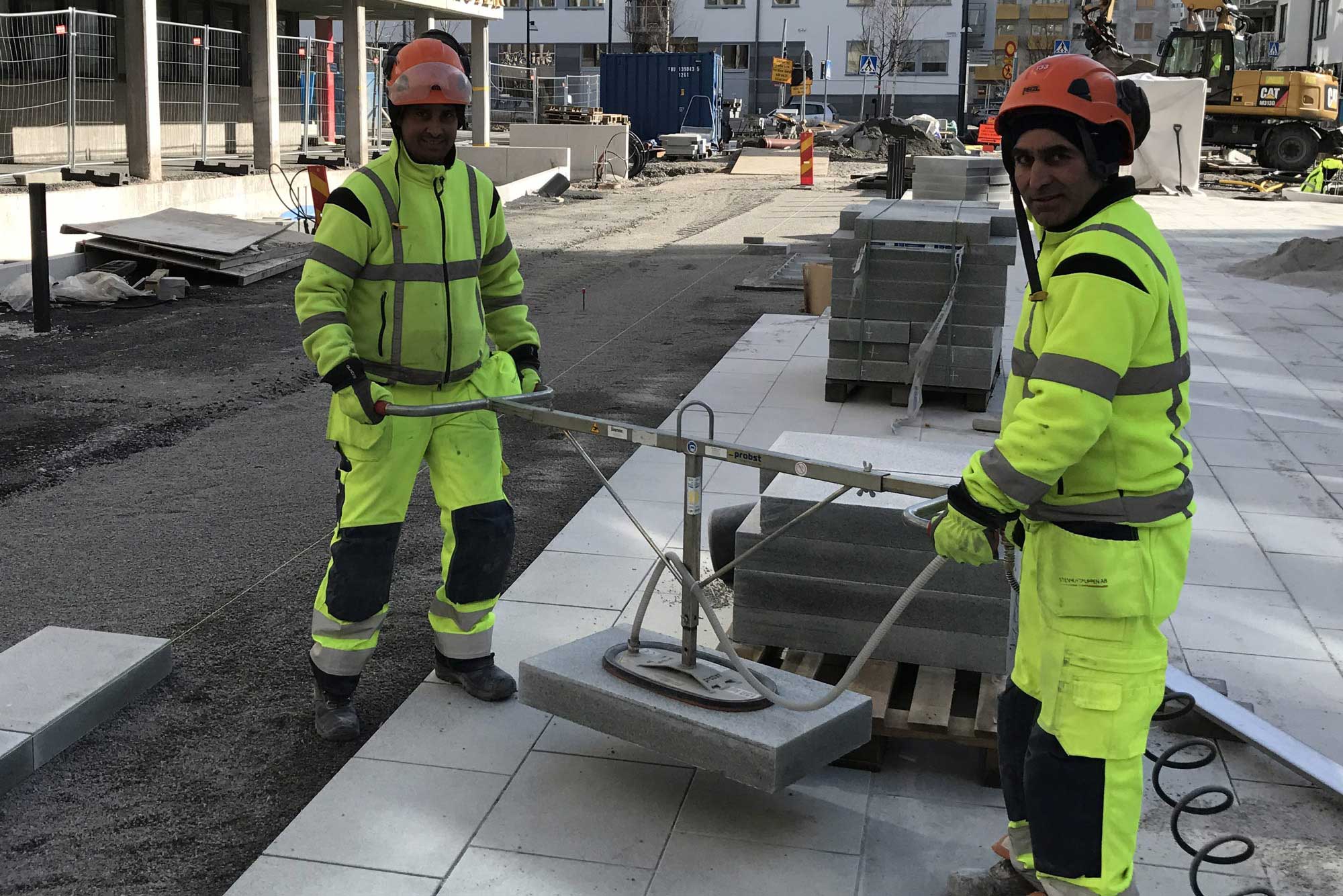 Två markarbetare med lyftverktyg