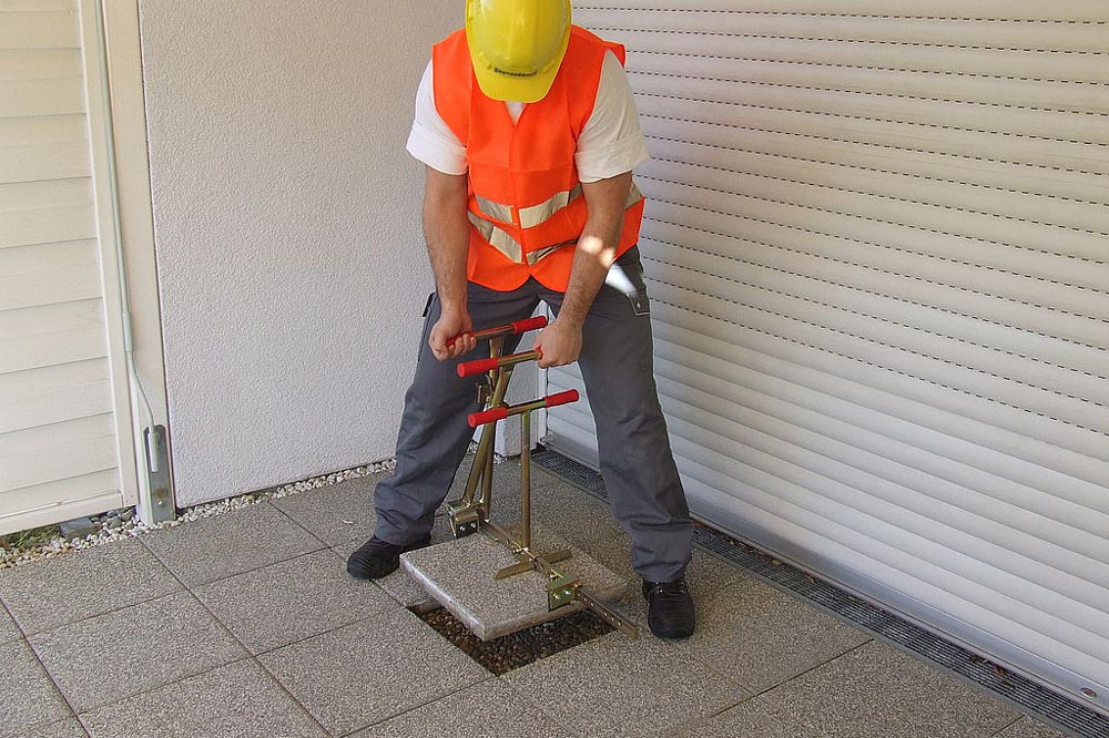 Arbetare lyfter upp en platta från en uteplats med Upptagare SZ