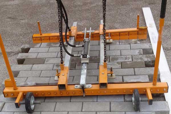 Orange Megatång på hjul med lyftkedjor och hydraulslang