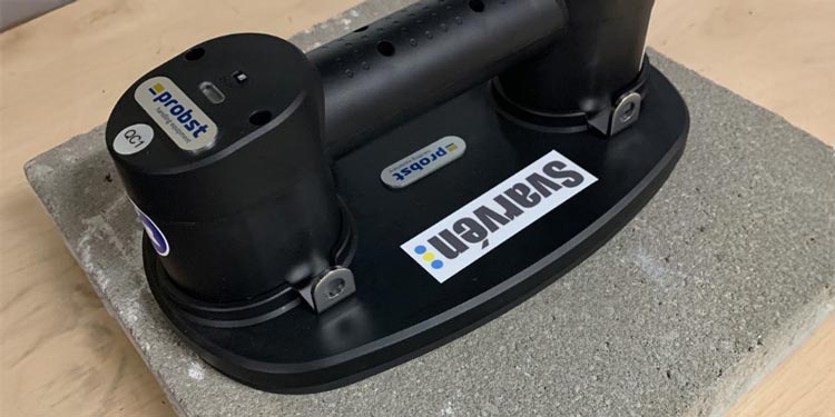 Svart vakuumhandtag fäst på en stenplatta
