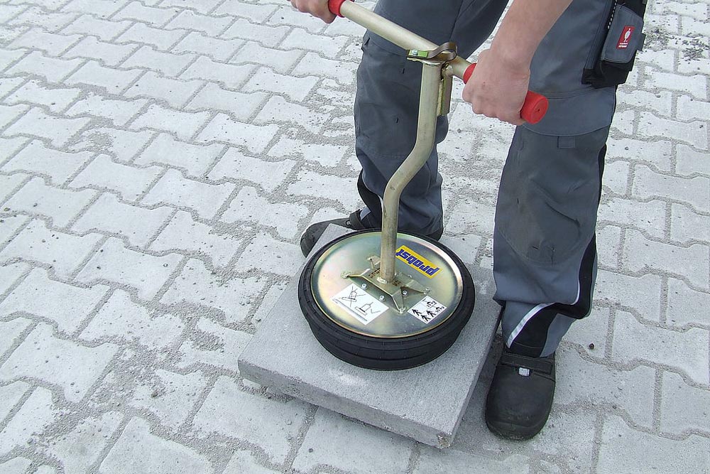 Person lyfter en betongplatta med vakuumlyften VH Däck